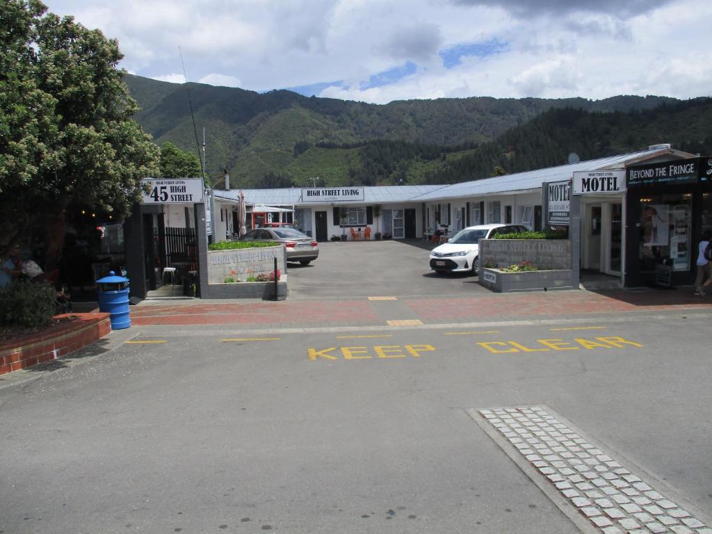 a parking lot with cars parked in front of a building at High Street Living Motel in Picton
