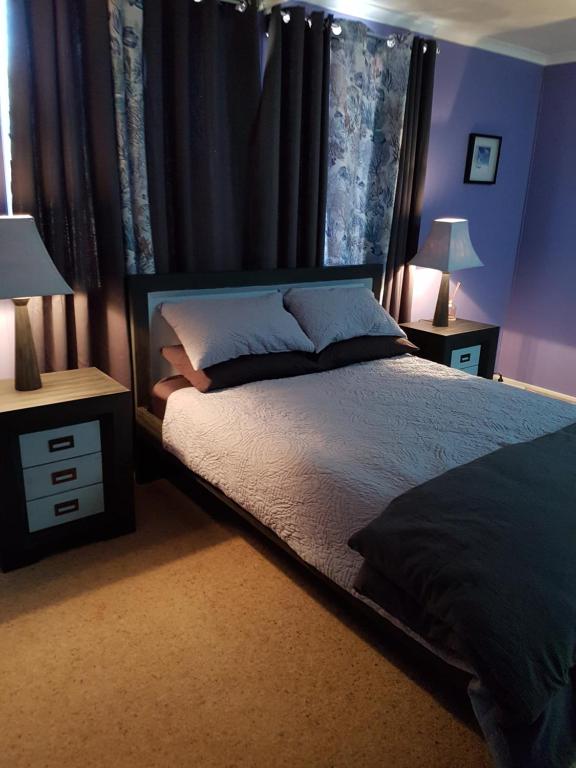 a bedroom with a bed and a night stand at Meekatharra Outback Beach House in Meekatharra
