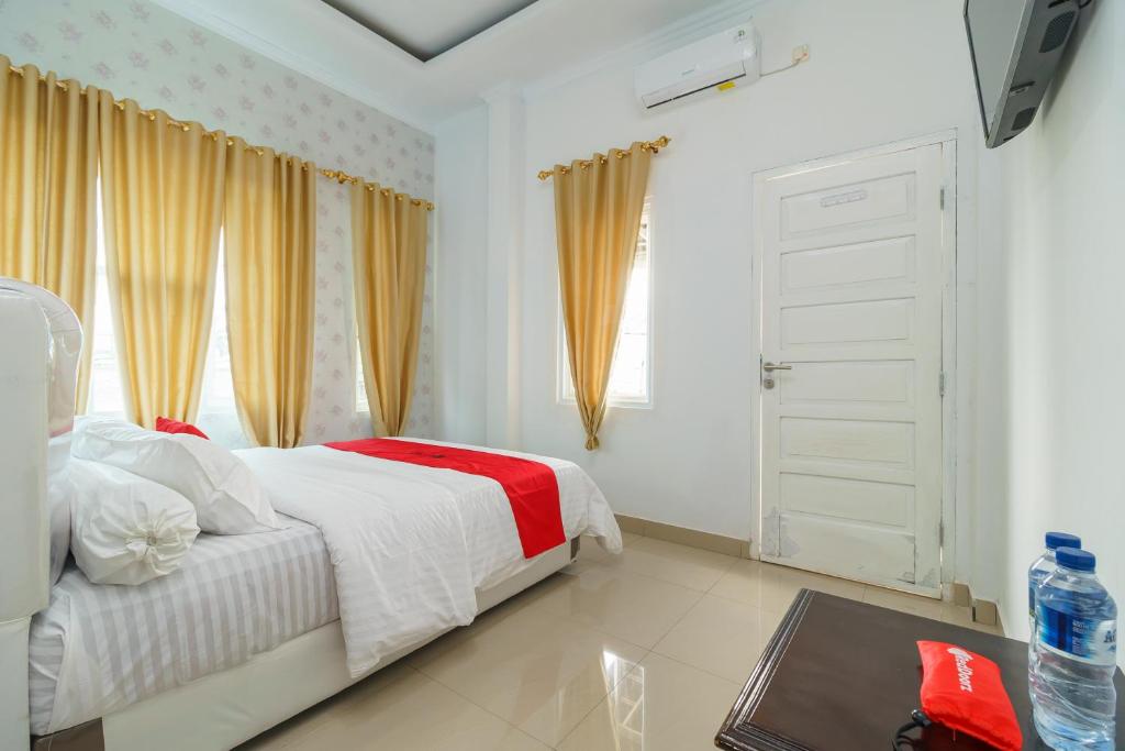 Postel nebo postele na pokoji v ubytování RedDoorz Syariah near Simpang Sekip Palembang