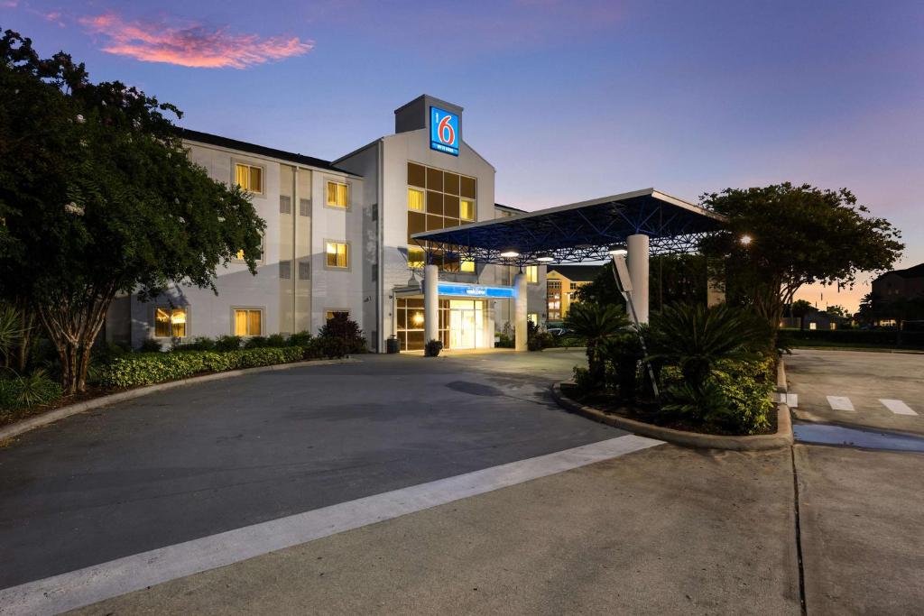 ein Hotel mit einem Gebäude mit einem Parkplatz in der Unterkunft Motel 6-Orlando, FL - International Dr in Orlando