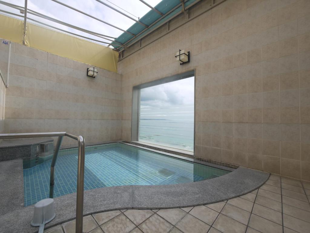 a swimming pool with a view of the ocean at Hotel Route-Inn Nago in Nago