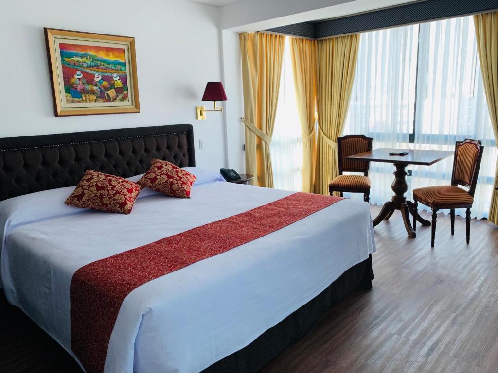 Habitación de hotel con cama y mesa con sillas en Hotel Monte Real, en Lima