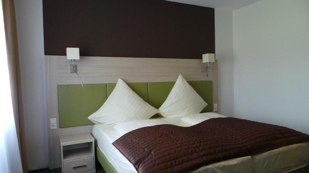 a bedroom with a bed with a brown and green headboard at Rhönblick Landhotel - Restaurant - Countrypub in Petersberg