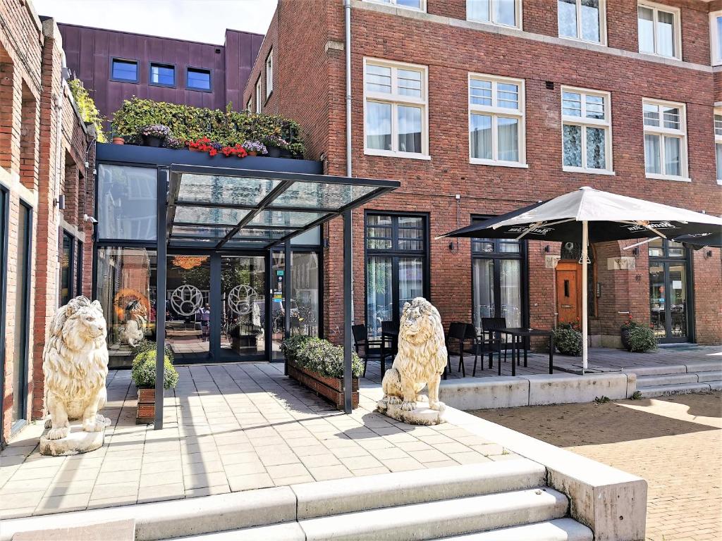 two statues of lions in front of a building at Chasse Hotel in Amsterdam