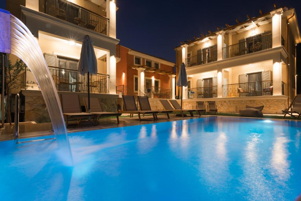 a swimming pool in front of a building at night at Perla Luxury Living in Parga