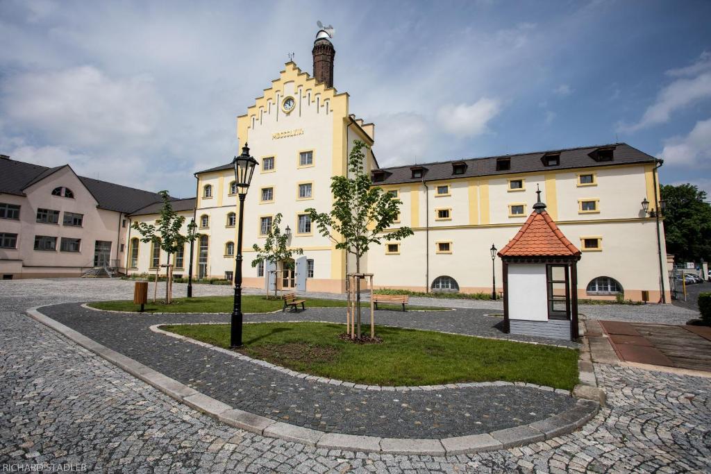 - un grand bâtiment blanc avec un kiosque devant dans l'établissement Hotel U Lípy, à Krušovice