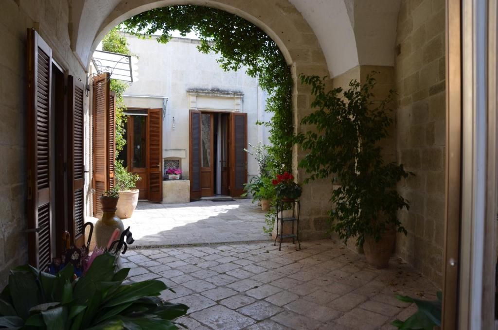 an entrance to a building with an archway and plants at B&B Lacurte in Martano