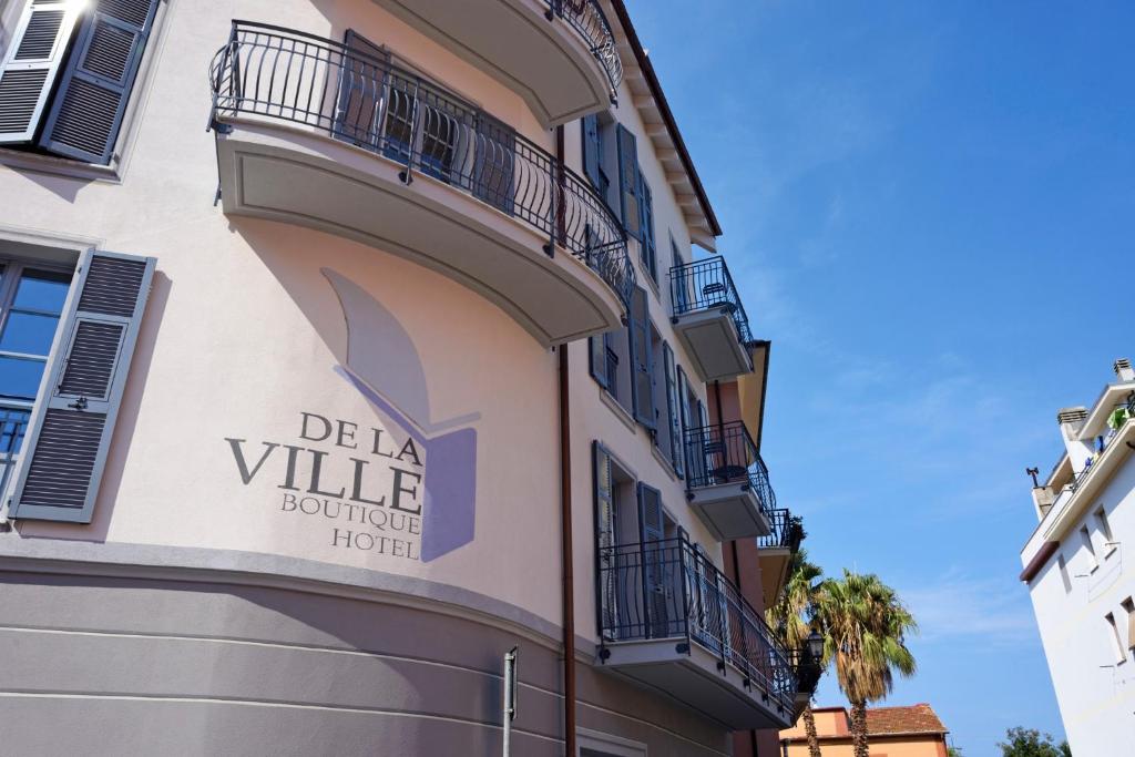 - un bâtiment avec un panneau indiquant l'hôtel de caractère del la ville dans l'établissement Boutique Hotel de la Ville, à Laigueglia