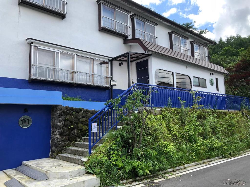 a white and blue house with a blue fence at Oyado Zen in Kusatsu