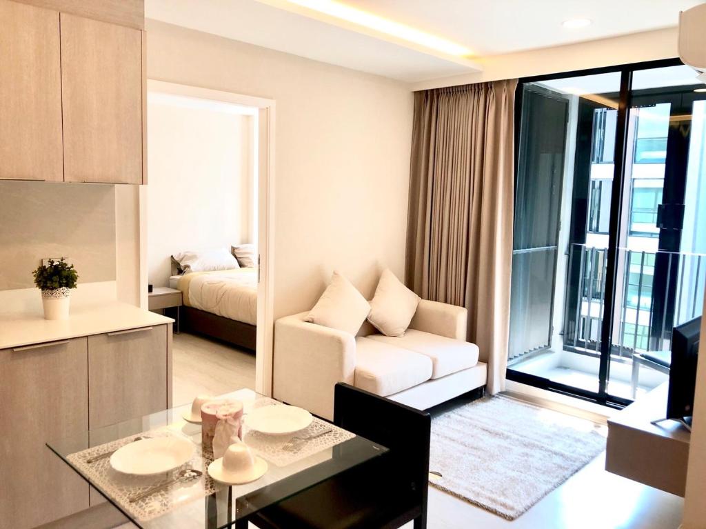 a living room with a couch and a room with a bed at BTS Thonglor New 2 bedrooms condo in Bangkok