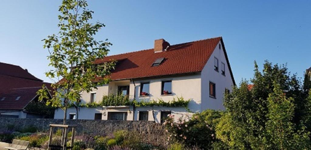 ein großes weißes Haus mit rotem Dach in der Unterkunft Ferienwohnung An der Dorfmauer in Sommerach