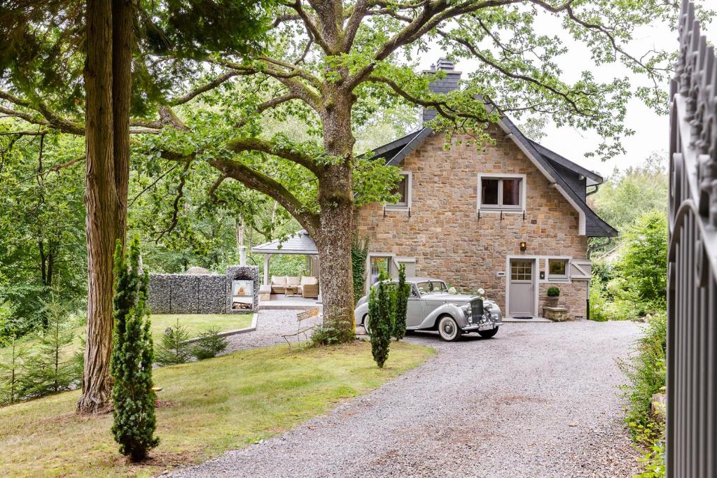 un coche aparcado frente a una casa de ladrillo en La Villa des Sources à 500 mètres du circuit en Francorchamps