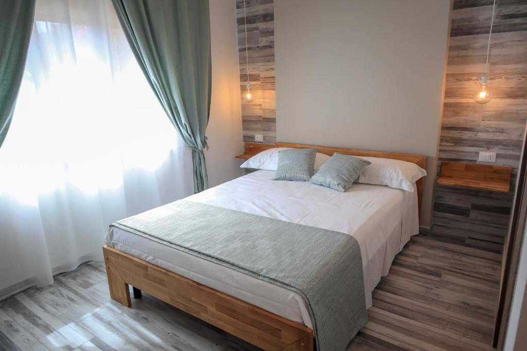 a bedroom with a large bed with a window at Vittoria Rooms in Quartu SantʼElena