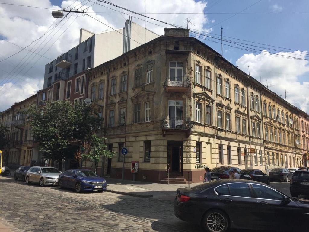 ein großes Gebäude mit davor geparkt in der Unterkunft Apartment studio near Forum Lviv in Lwiw