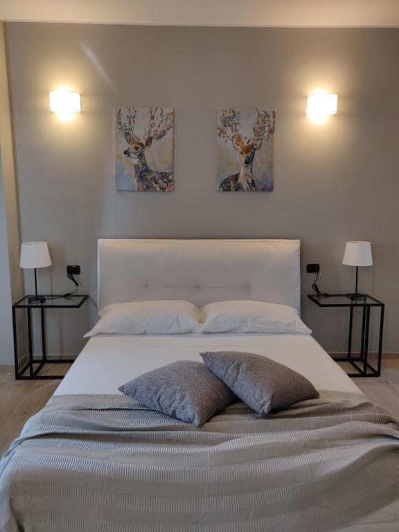 sypialnia z dużym łóżkiem z dwoma obrazami na ścianie w obiekcie Dimora Dei Cento w mieście Pescara