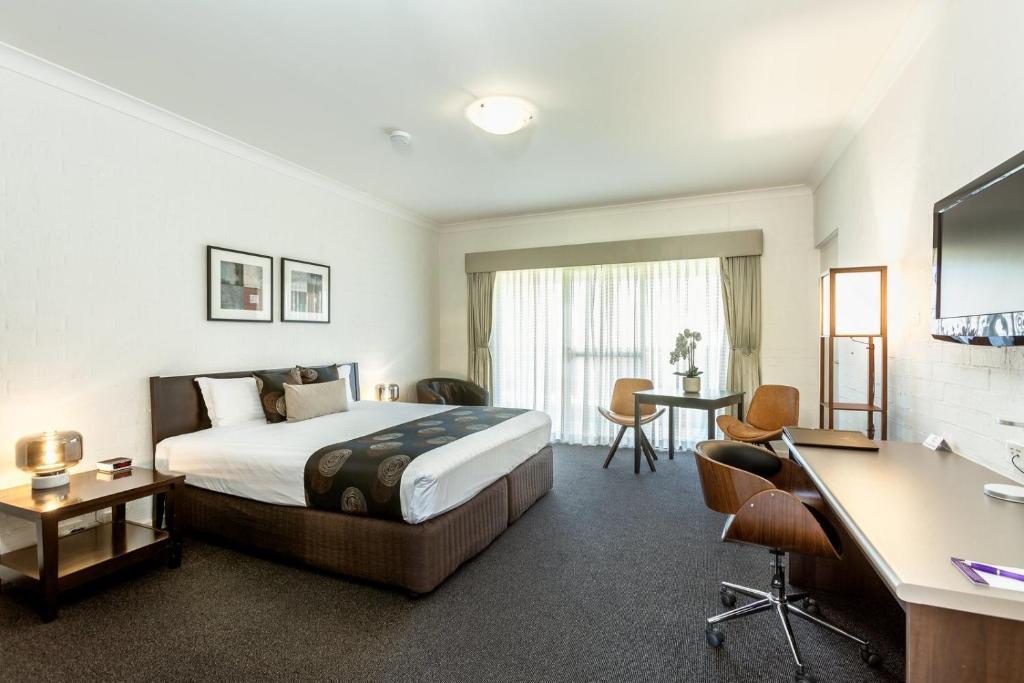 um quarto de hotel com uma cama e uma secretária em Blazing Stump Motel & Suites em Wodonga