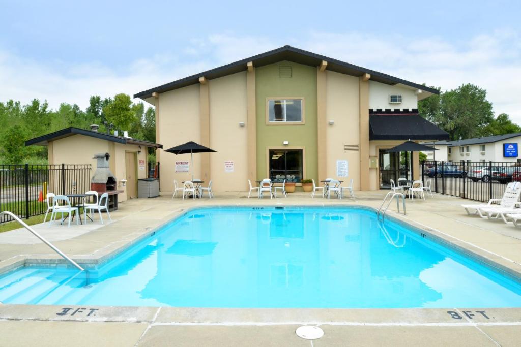 a swimming pool with chairs and a building at Valued Stay Madison in Madison