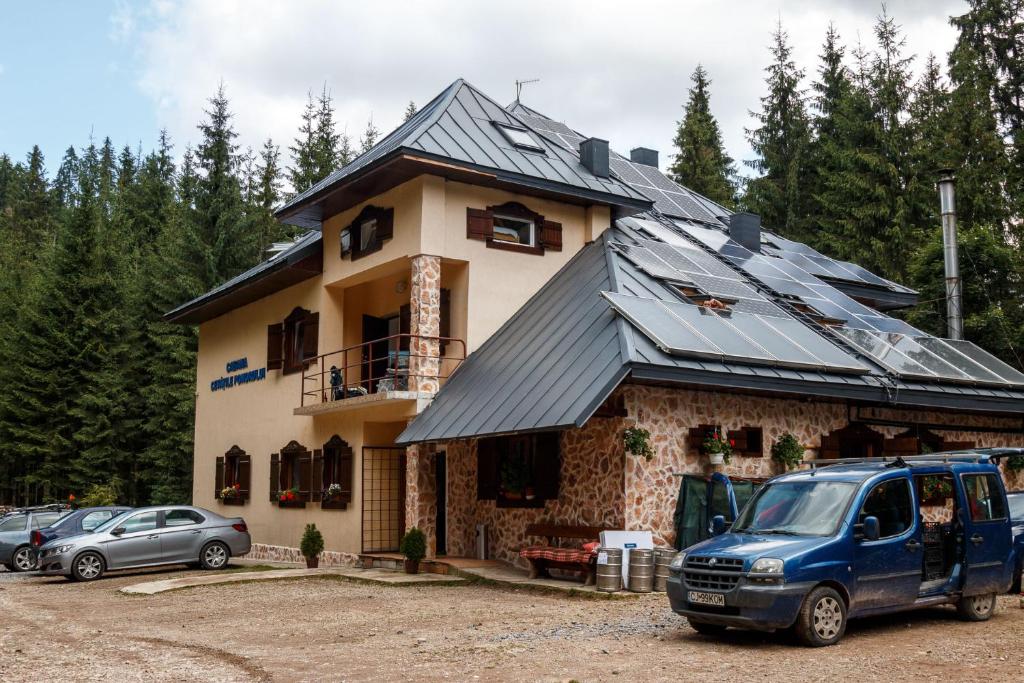 a blue van parked in front of a house at Pension Cabana Cetatile Ponorului in Padis