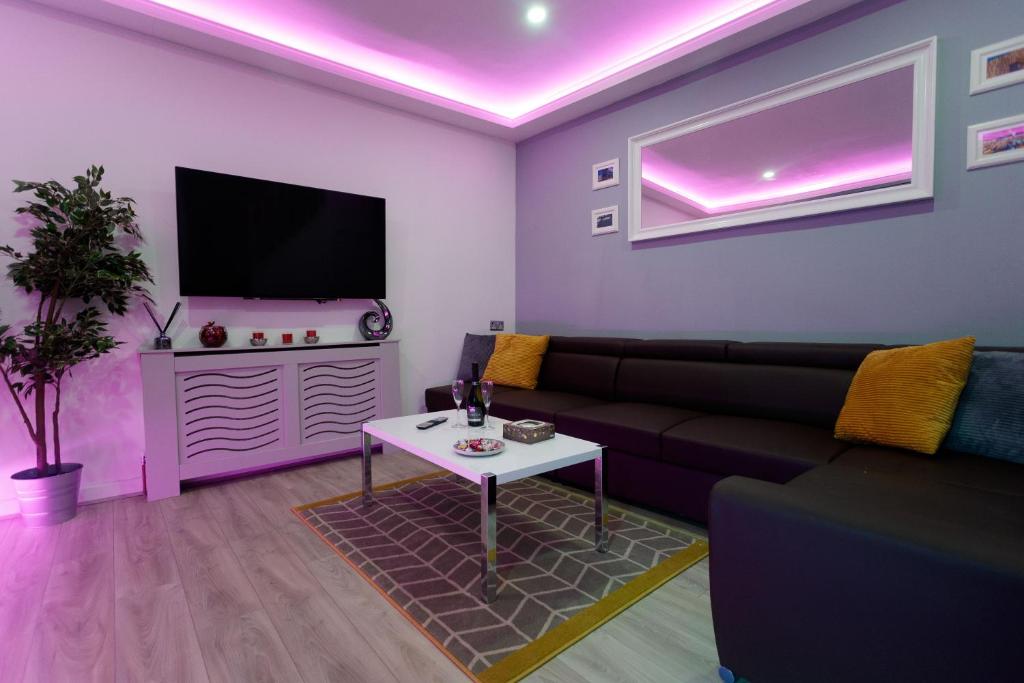 sala de estar con sofá y TV en TOWLER HOUSE APARTMENTS 6 beds in 3 bedrooms en Leeds