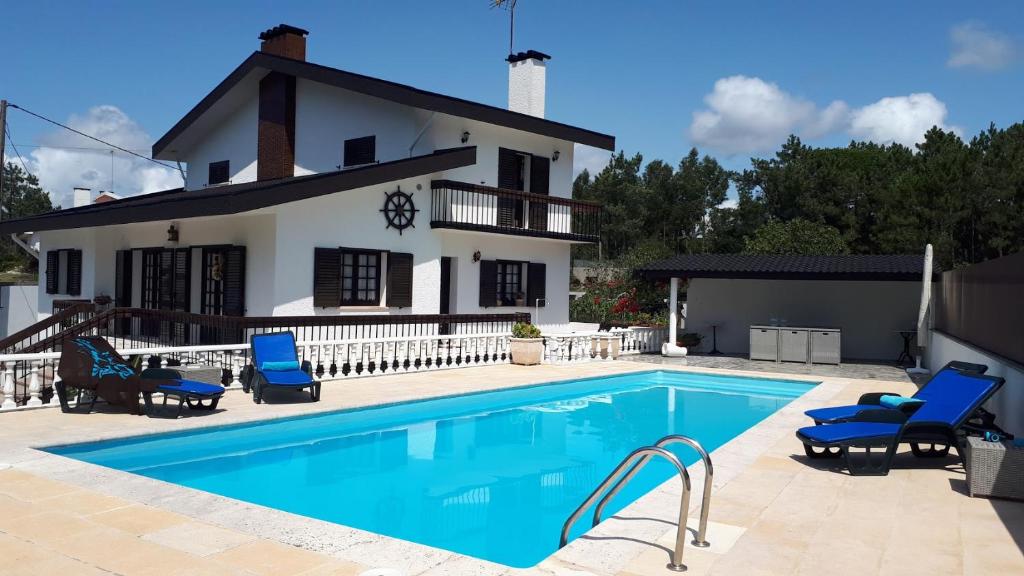 a villa with a swimming pool in front of a house at 600 Local Accommodation in Amorosa