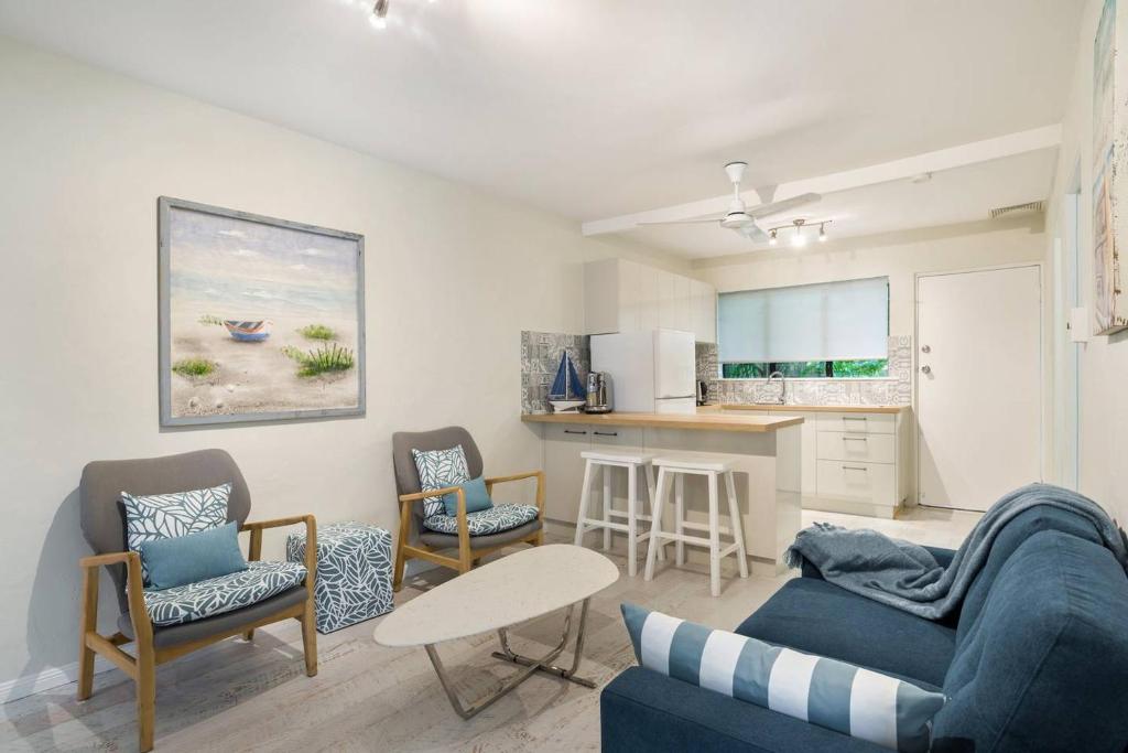 a living room with a couch and chairs and a kitchen at A cozy Palm Cove unit 3 with a private garden in Palm Cove