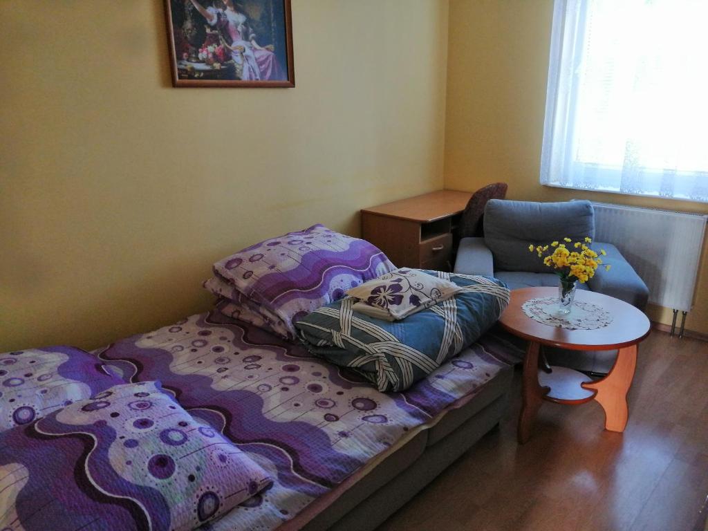 オルシュティンにあるMieszkanie Jarocka 4のベッド、テーブル、椅子が備わる小さな客室です。