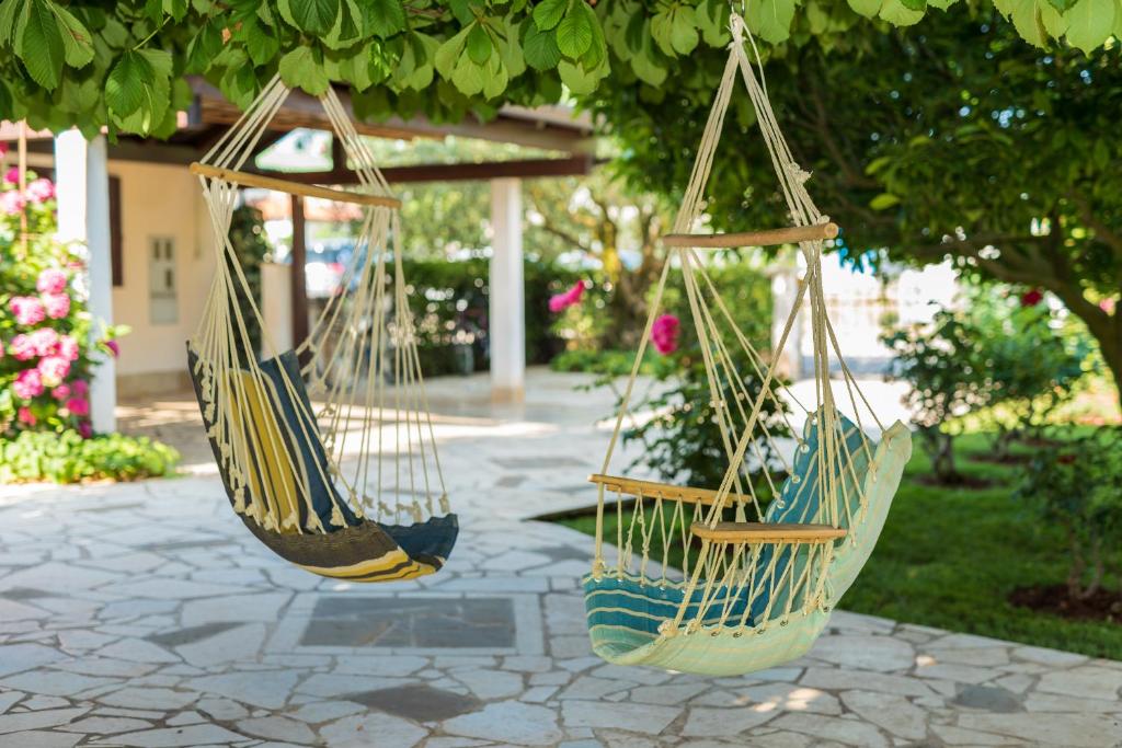 two hammocks hanging from a tree in a garden at B&B Carmela in Umag