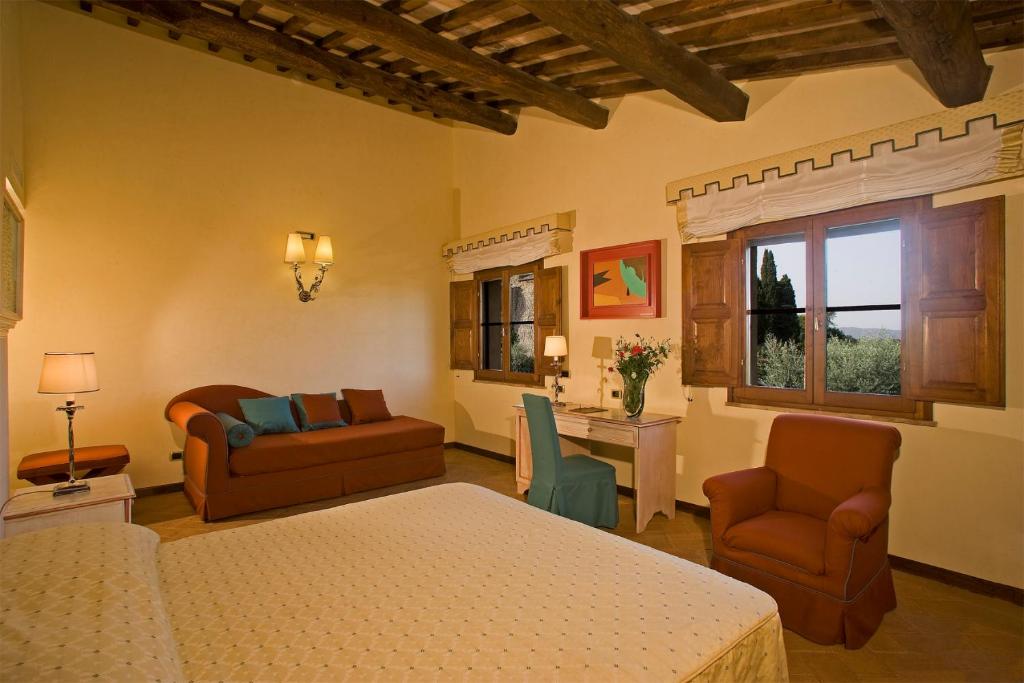 a hotel room with a bed, chair and a tv at Sovana Hotel & Resort in Sovana