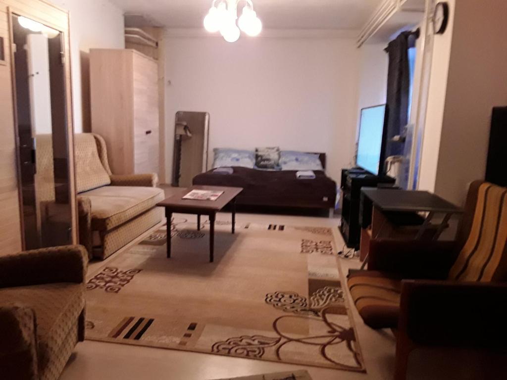 een woonkamer met een bank en een tafel bij Tunnel Family Apartmanház Pécs in Pécs