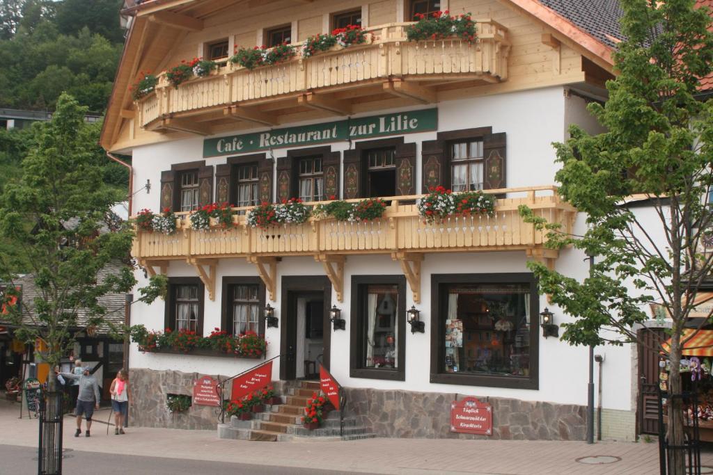 a building with a sign that reads cafe restaurant and little at Gästehaus Zur Lilie in Triberg