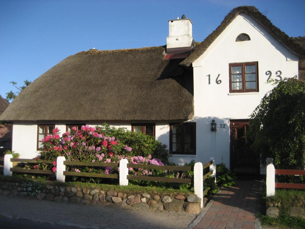 una casa bianca con tetto di paglia di Friesenhaus App. I a Westerland