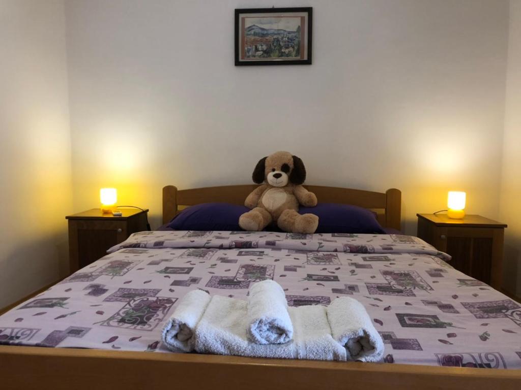 a teddy bear sitting on a bed with towels at Apartments Avram in Vršac