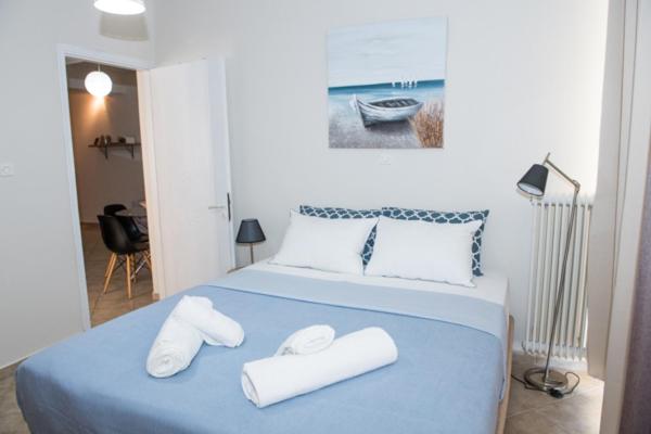 a bedroom with a blue bed with two white towels at A beautifull 2nd floor apartment close to the Port in Kalamata