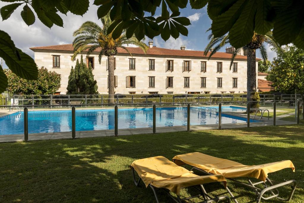 a building with two chairs and a swimming pool at Parador de Cambados in Cambados
