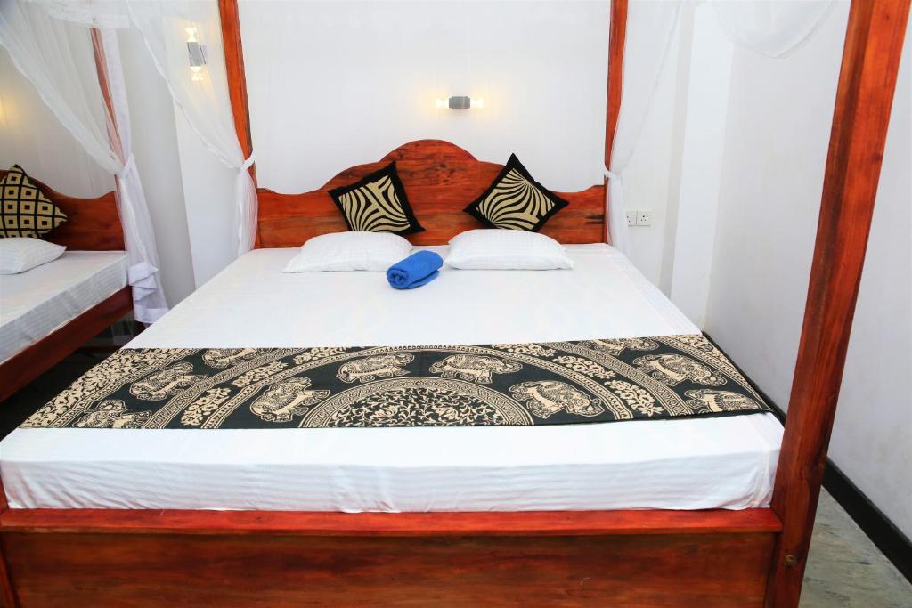 a bedroom with a bed with a wooden headboard at Mountain Relax Inn in Weligama