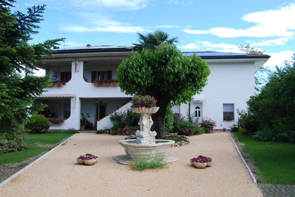 a large white house with a fountain in the yard at Antico Borgo in San Daniele del Friuli