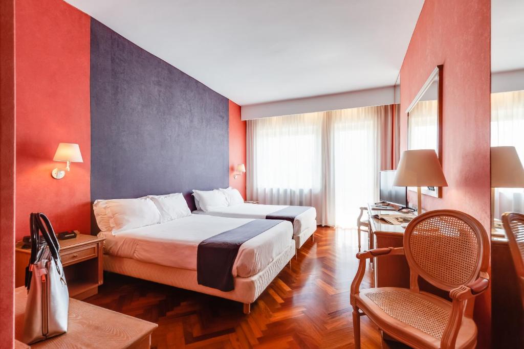 um quarto de hotel com uma cama e uma cadeira em Culture Hotel Villa Capodimonte em Nápoles