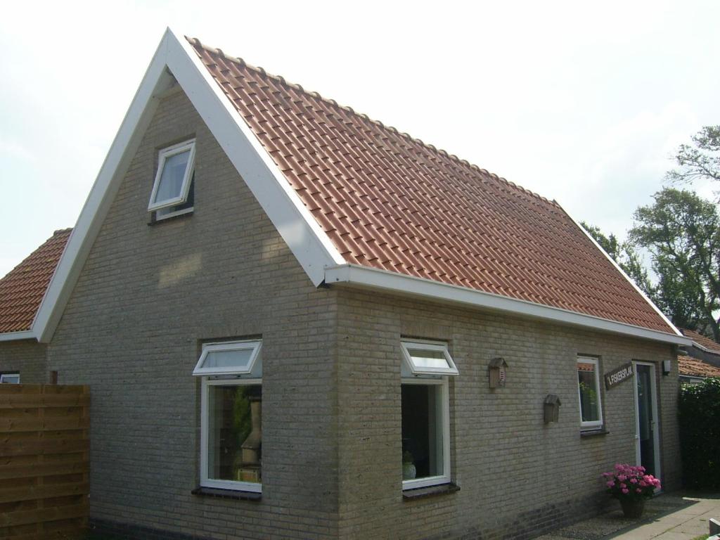 ein Backsteinhaus mit braunem Dach in der Unterkunft T Fiskersplak in Hollum
