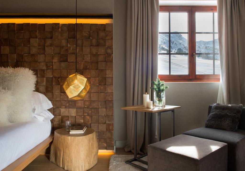 ein Schlafzimmer mit einem Bett, einem Stuhl und einem Fenster in der Unterkunft Grau Roig Andorra Boutique Hotel & Spa in Grau Roig