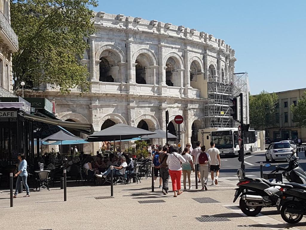 a group of people walking down a street in front of a building at Dolce NÎMES CENTRE in Nîmes