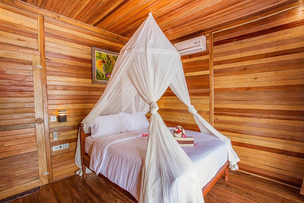 Säng eller sängar i ett rum på Wooden Beach Sunset Cottages