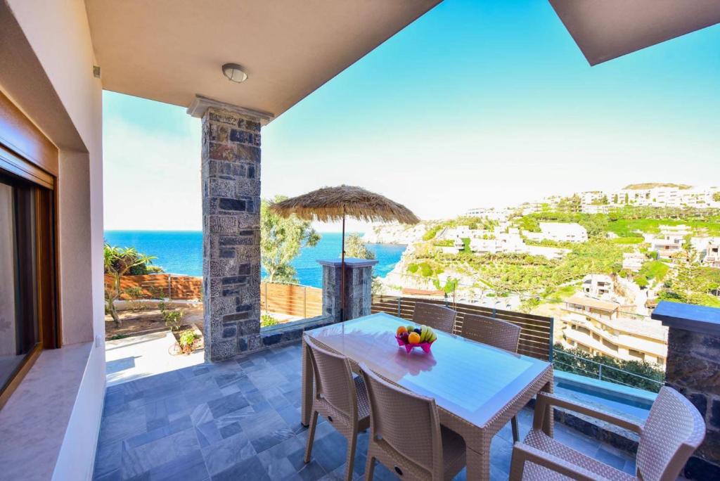 a dining room with a table and a view of the ocean at Sea Front Panorama Villa Private Pool in Agia Pelagia