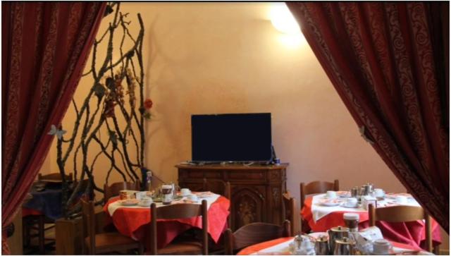 a dining room with two tables and a television at Albergo Sandra in Rome