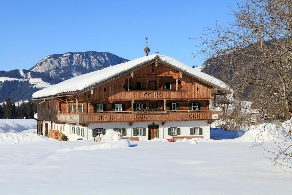 ein großes Holzhaus mit Schnee auf dem Dach in der Unterkunft Ferienhaus Hinterebenhub in Hopfgarten im Brixental
