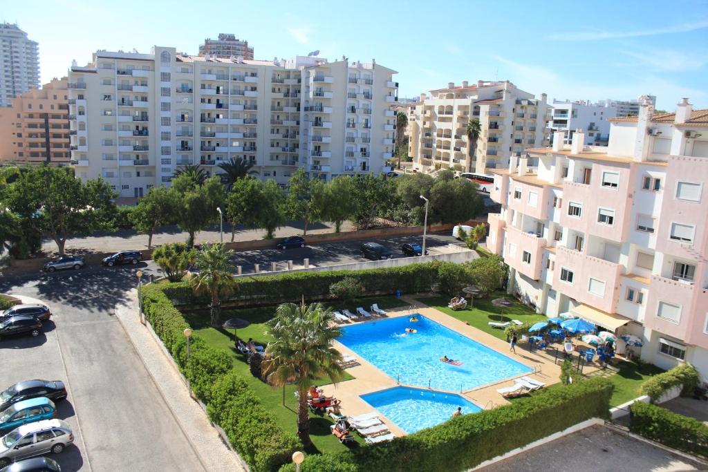 an apartment with a swimming pool and buildings at Castelos da Rocha in Portimão