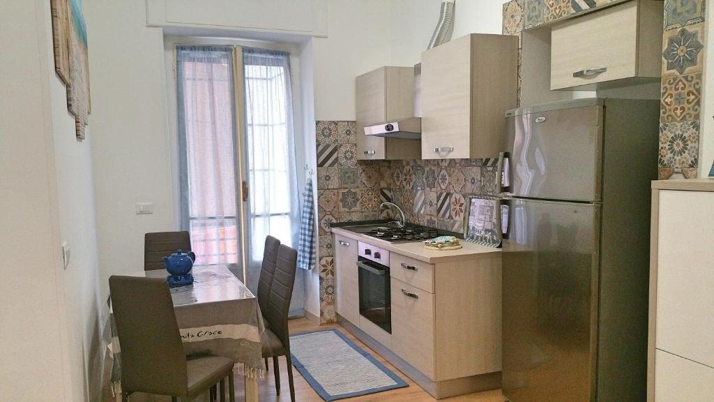 Hotel Casa Koribut, a kitchen with a stainless steel refrigerator and a table at Casa Koribut in Sanremo