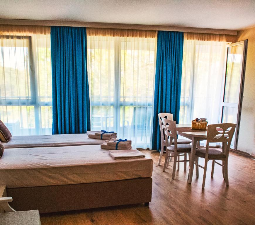 Schlafzimmer mit einem Bett und einem Tisch mit Stühlen in der Unterkunft Zornitsa Apart in Primorsko