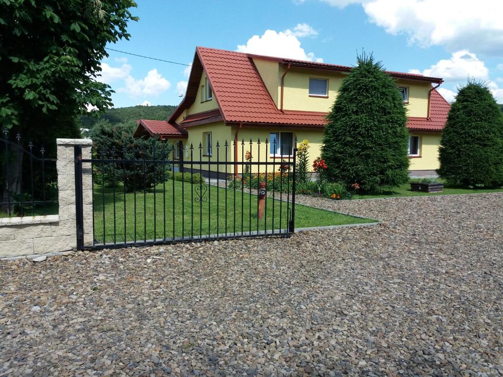 uma cerca em frente a uma casa em olszanka em Ustrzyki Dolne