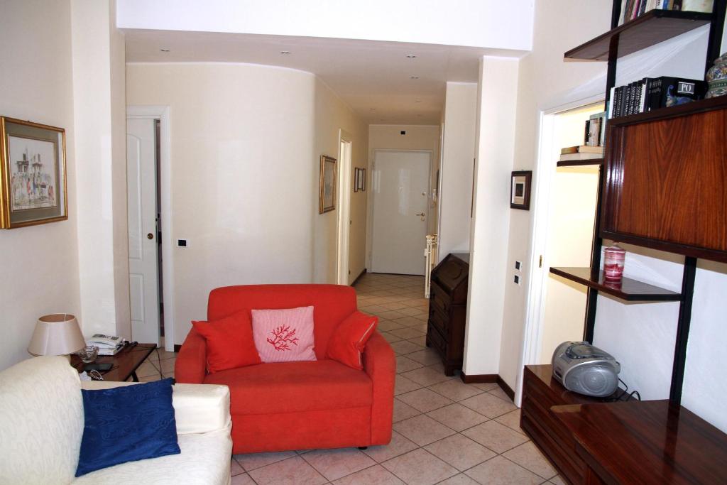ein Wohnzimmer mit einem roten Stuhl und einem Sofa in der Unterkunft Delizia apartment in Rapallo