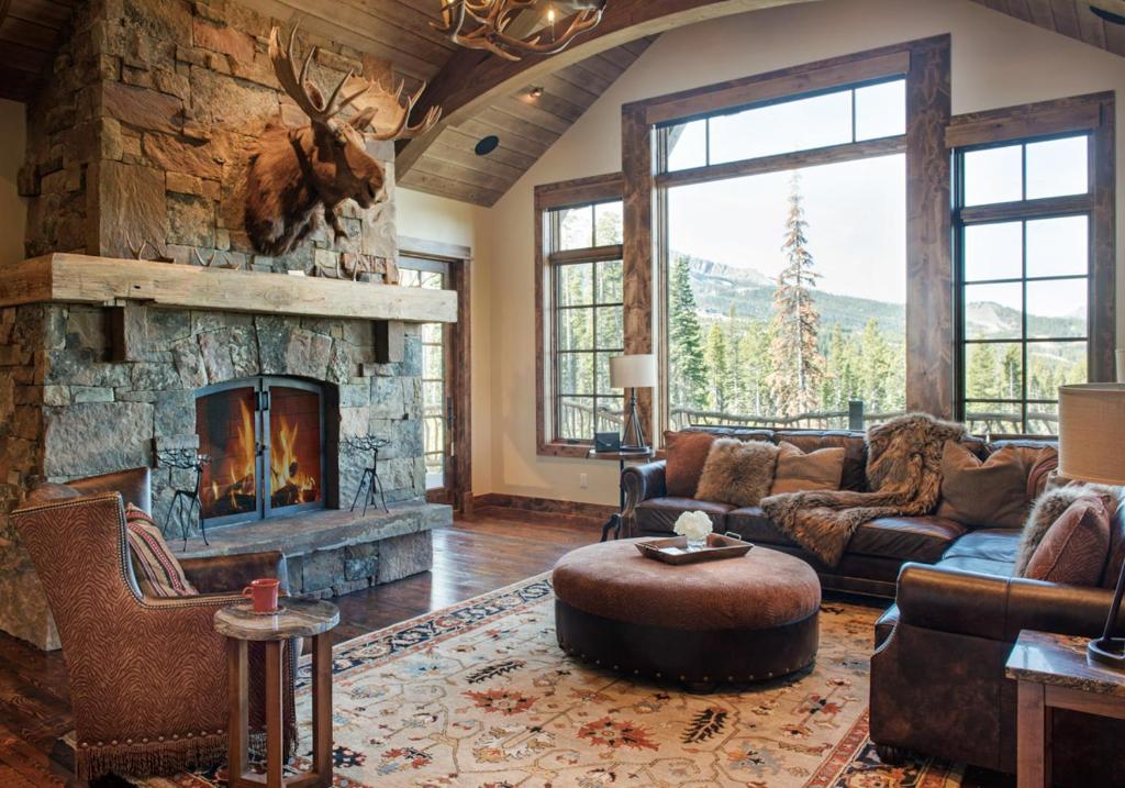 a living room with a large stone fireplace at Hoos Views in Big Sky Mountain Village